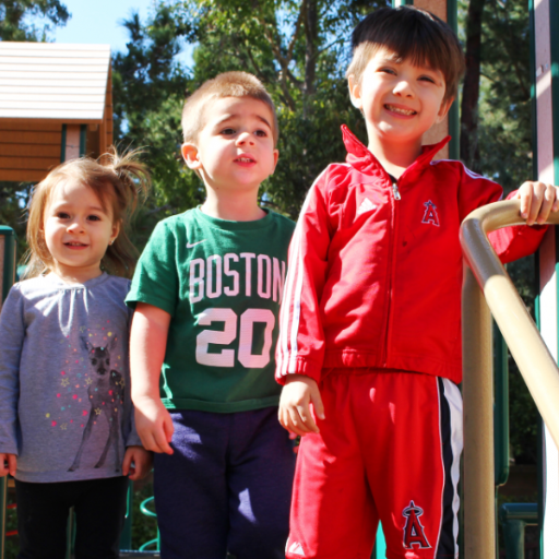 Happy diverse children playing with colorful building blocks in a bright classroom